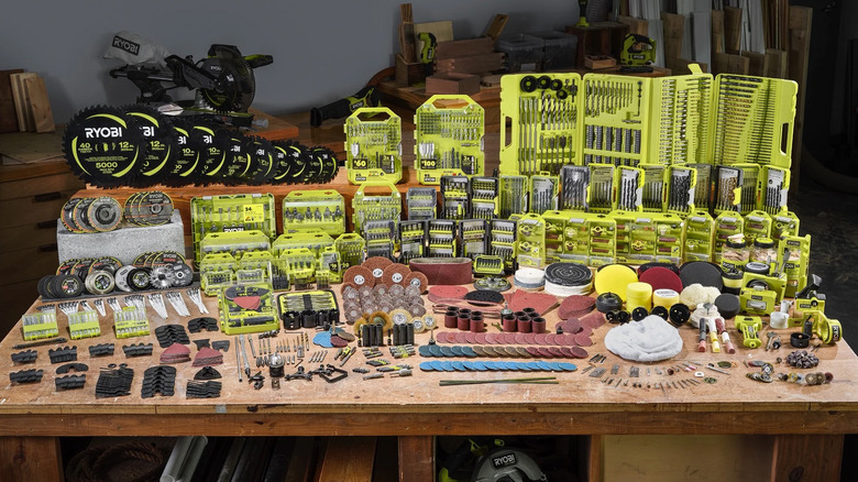 A workbench full of Ryobi tools, bit sets, and other accessories