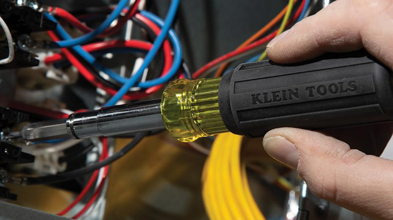 A man using a screwdriver on an electrical panel