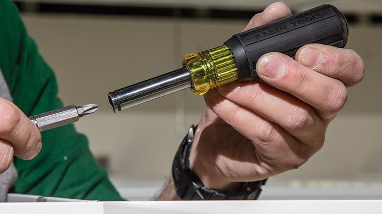 A man changing the bit in a multi-bit screwdriver