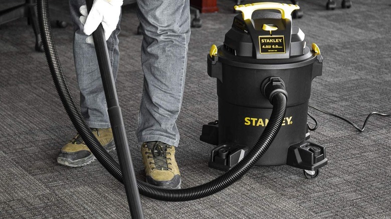 Man using Stanley Shop Vacuum on carpet