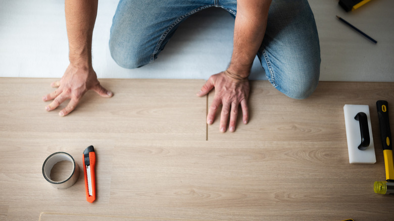 installing flooring with utility knife prominent