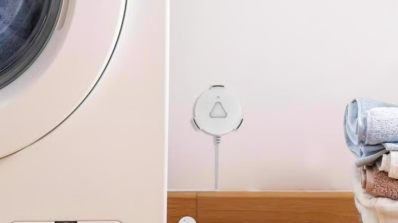 Feit smart water leak sensor installed next to a washing machine