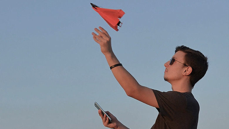 A man testing out the PowerUp 4.0 Smartphone-Controlled Paper Airplane Kit