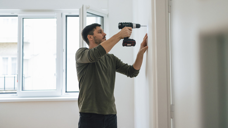 Man using cordless power drill at home