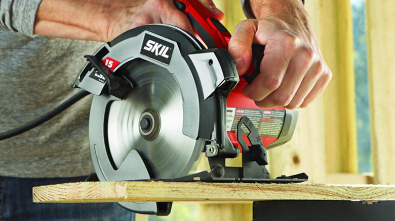 Cutting wood board with Skil circular saw.