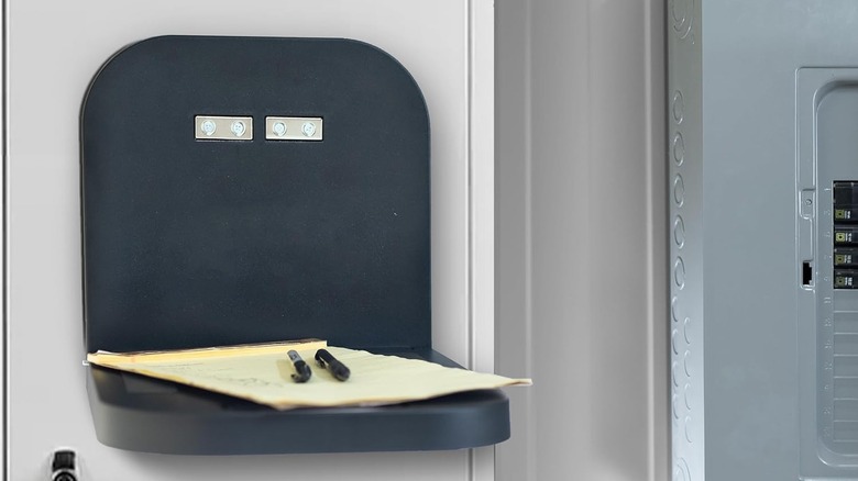 The Vivo Magnetic Portable Laptop attached to a wall holding up pens and a piece of paper
