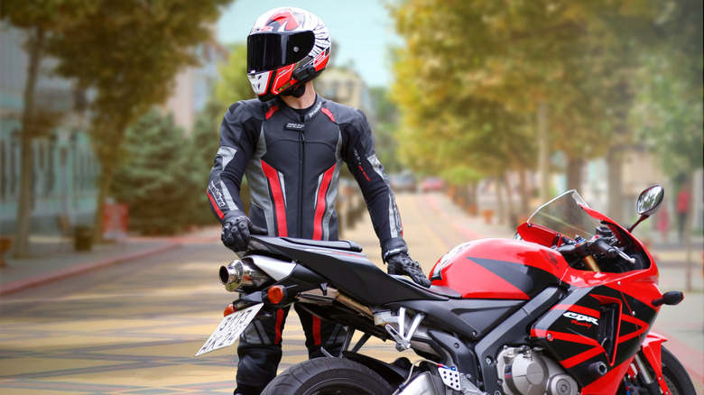 rider standing with Honda CBR motorcycle