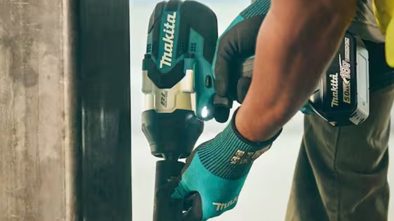 worker holding Makita impact wrench