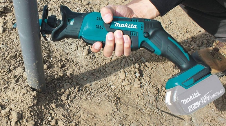 Person using Makita XRJ01Z Reciprocating Saw on pipe