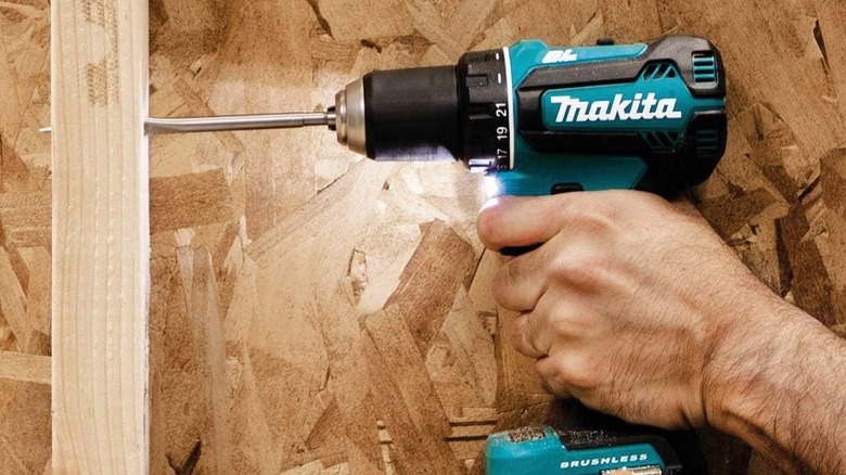Makita XFD131 drill/driver drilling a hole in a wooden wall stud