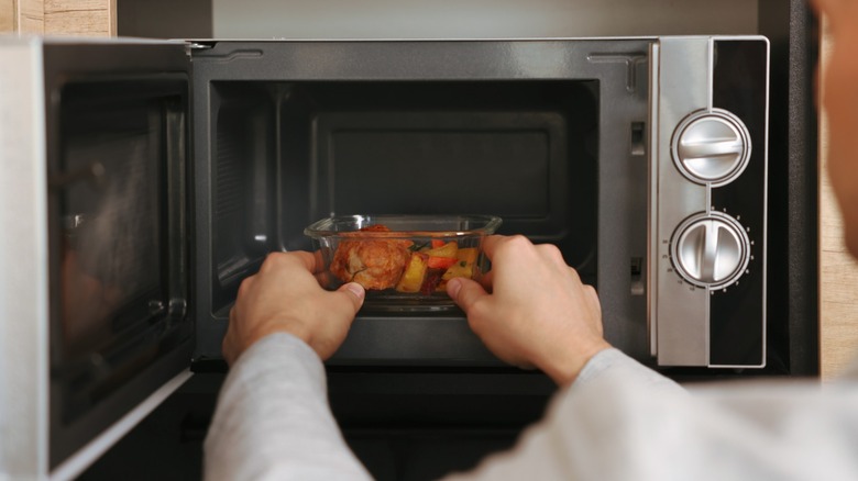 a man putting food in a microwave