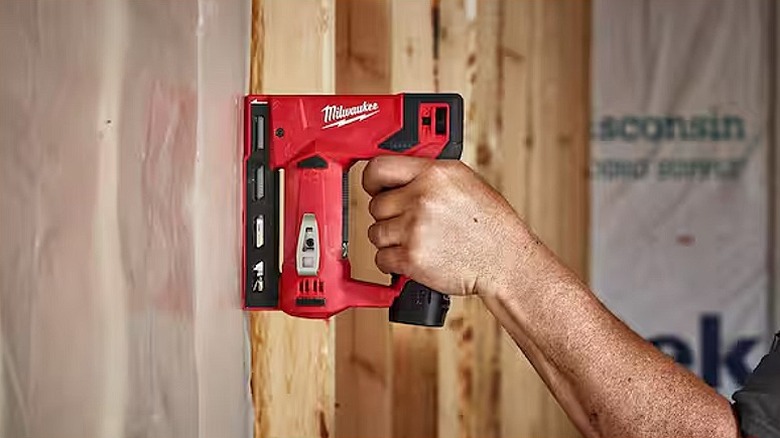 Stapling together pieces of wood using a Milwaukee crown stapler.