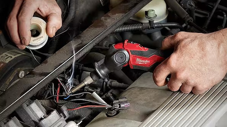 Using a soldering iron to join multiple electrical wires.