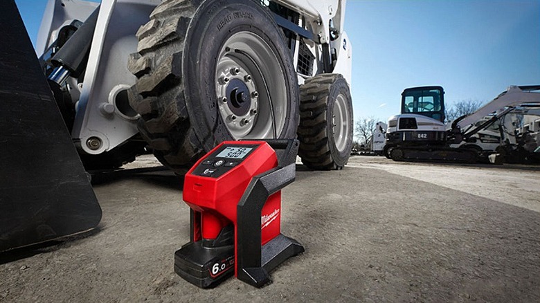 Portable inflator placed on a road with big trucks and tractors in the background.