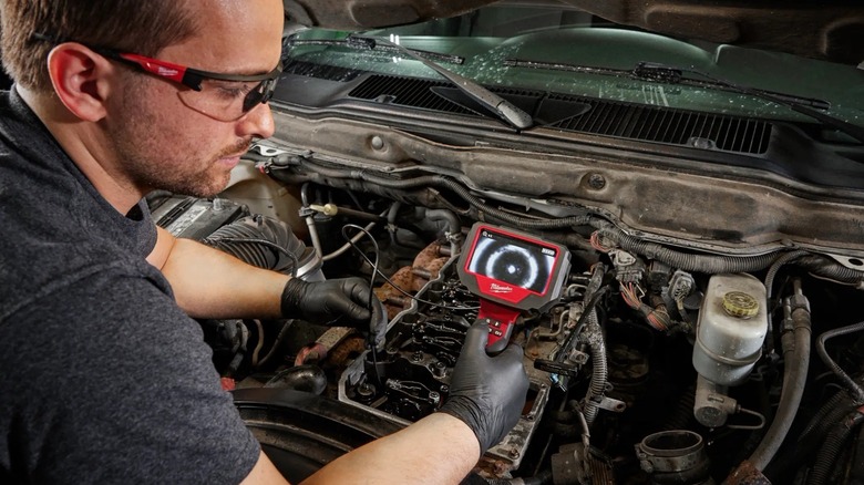 Mechanic using Milwaukee borescope
