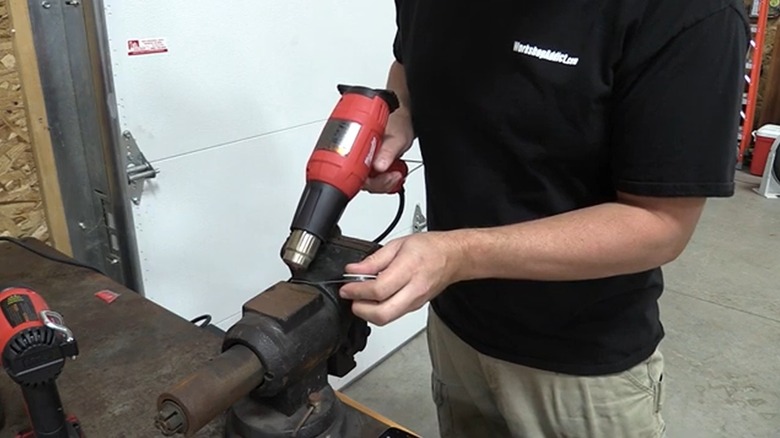 Person using Milwaukee heat gun