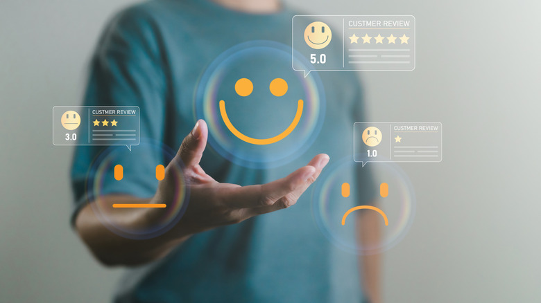 A person holding out their hand while several holographic customer reviews float in and around their palm.