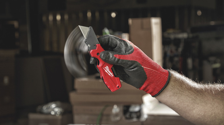 The Milwaukee FASTBACK 6-in-1 Folding Utility Knife held in hand.