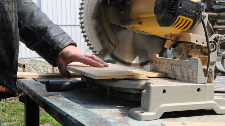 lowering miter saw blade down to a board