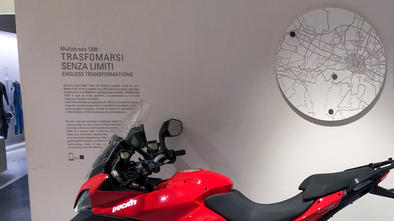 Red Ducati Multistrada on display alongside its engine