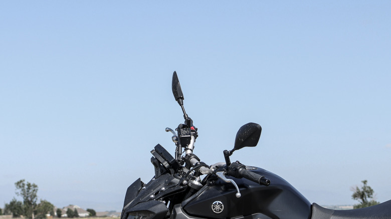 Profile of a black Yamaha MT09 in front of grassy field