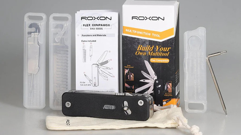 A black multitool on a pouch in front of several accessory kits