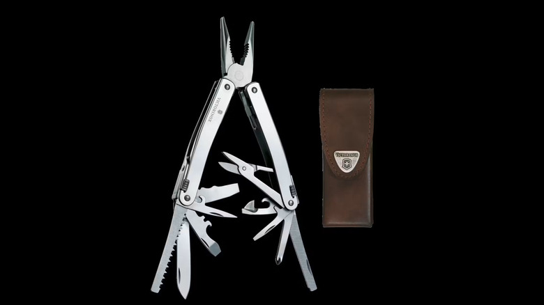 An open silver multitool with several tools out on a black background, next to a brown leather pouch