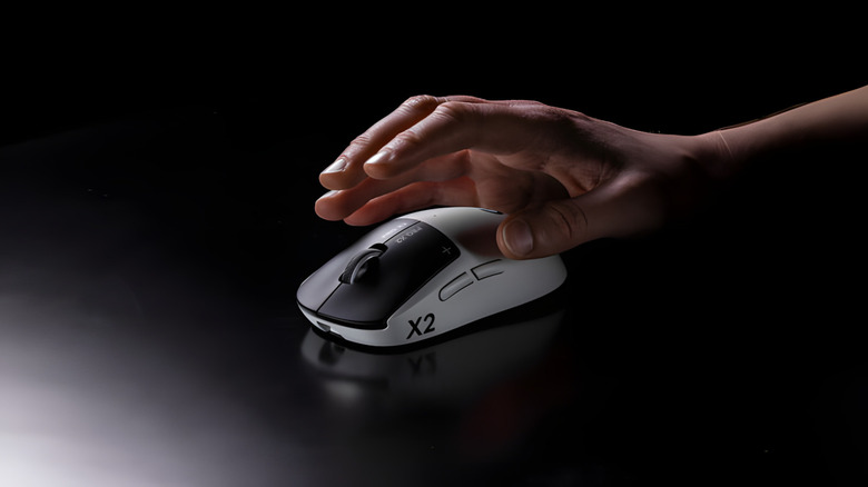 A hand reaching for the Logitech Pro X2 Superstrike