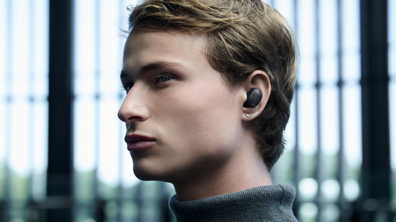A man wearing a pair of Sony earbuds outside