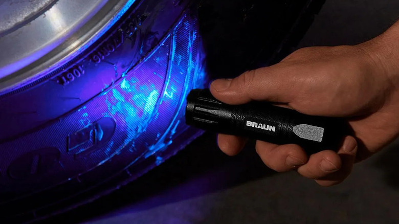 Braun UV flashlight with a vehicle tire