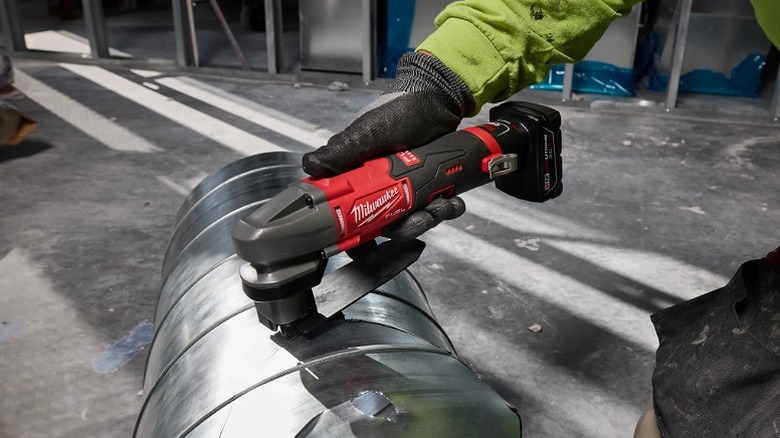 Using a scroll shear tool on metal sheets.