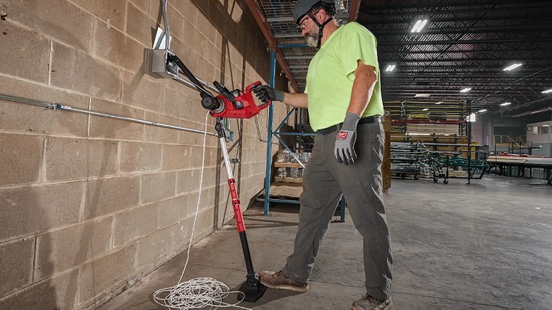 Worker using a wire puller support to work on steel frames.