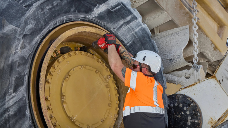 Milwaukee M18 Fuel 3/4 inch extended anvil torque high torque impact wrench being used on a mining vehicle tire
