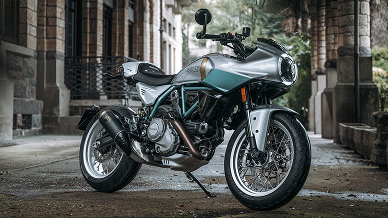 A gorgeous silver and aquamarine Ducati Formula 73 limited edition cafe racer bike outside a building in the shade.