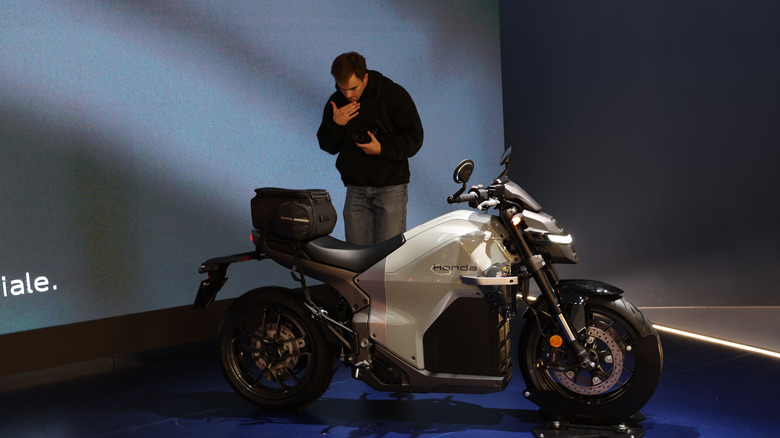 A gray and silver Honda WN7 motorbike on an elevated platform at an indoor exhibition.