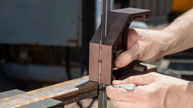 A person using combination square while metalworking