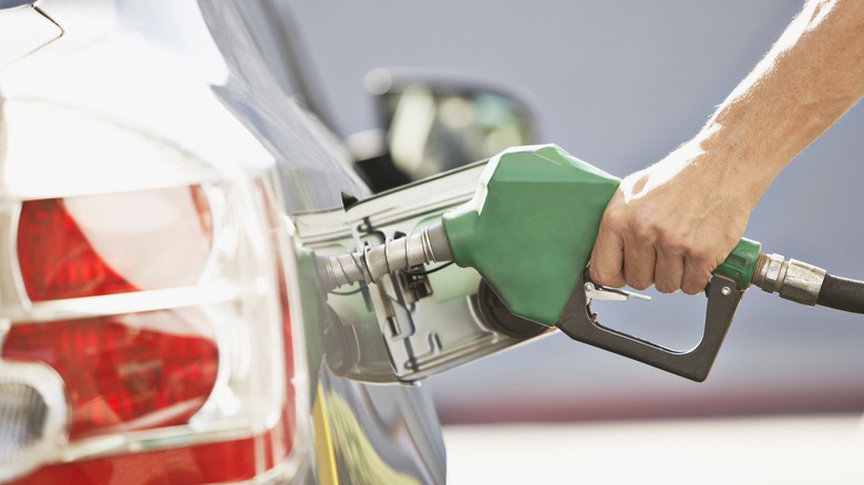 a person adding gas to their car