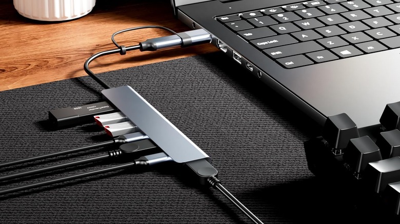 A USB hub plugged into a laptop and a keyboard is nearby.