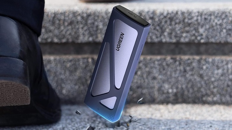 A Ugreen external SSD enclosure falling onto the ground.