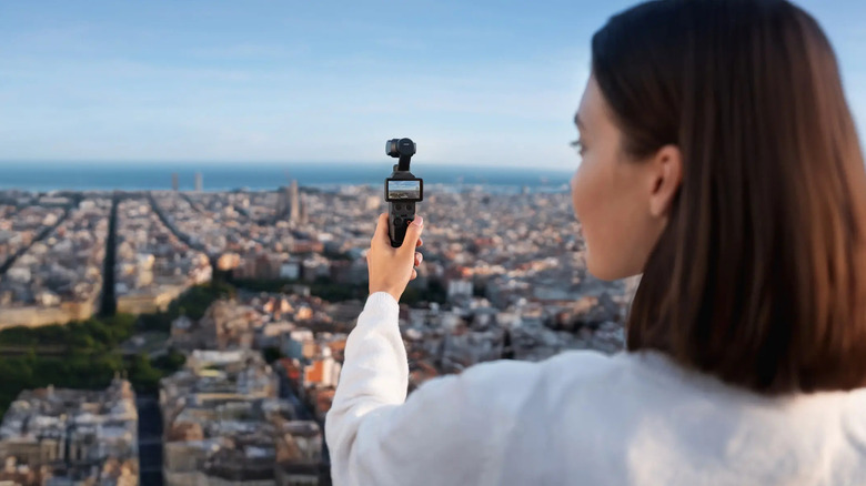 A person using the DJI Osmo Pocket 4 to capture a city skyline