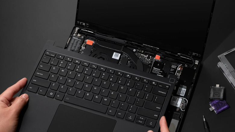 A person swapping out a keyboard and other components in the Framework Laptop 13 Pro