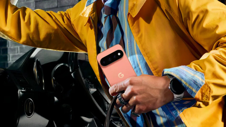 A person holding an orange Pixel 11 Pro XL in hand.