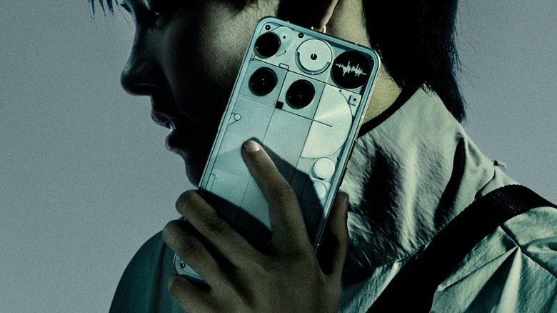 A person speaking on the phone, holding a Nothing Phone 3.