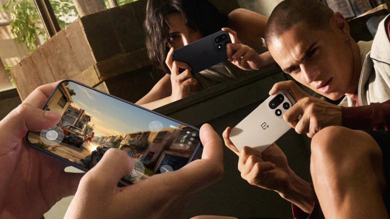 Three persons playing games on OnePlus 15.
