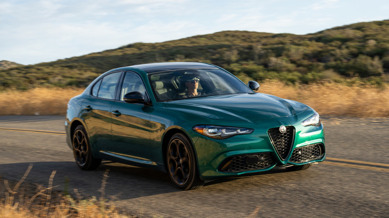 A green 2025 Alfa Romeo Giulia driving on a rural road