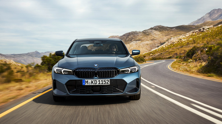 A front view of a 2025 BMW 3 Series driving down a winding road.