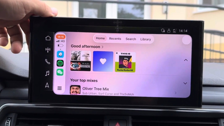 A person showing the Spotify interface in an Apple CarPlay system
