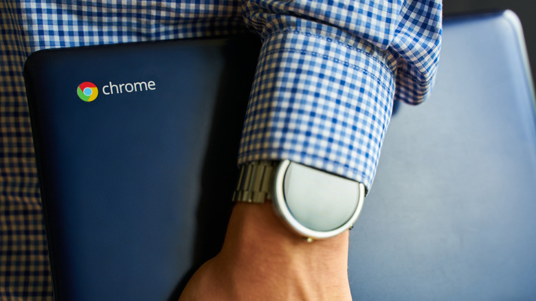 Asus Chromebook in man's hand with watch on it