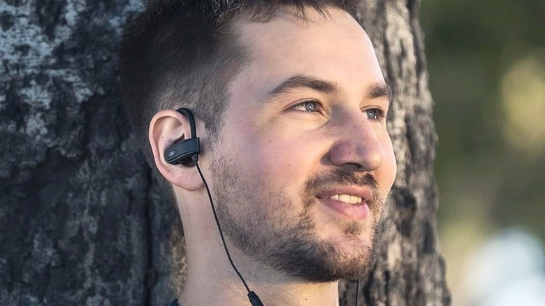A bearded man wearing Avantree C171 earbuds.