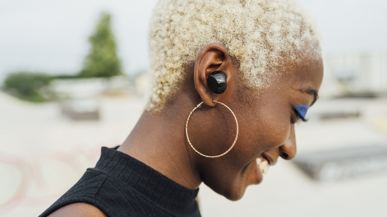 A woman with earbuds in.